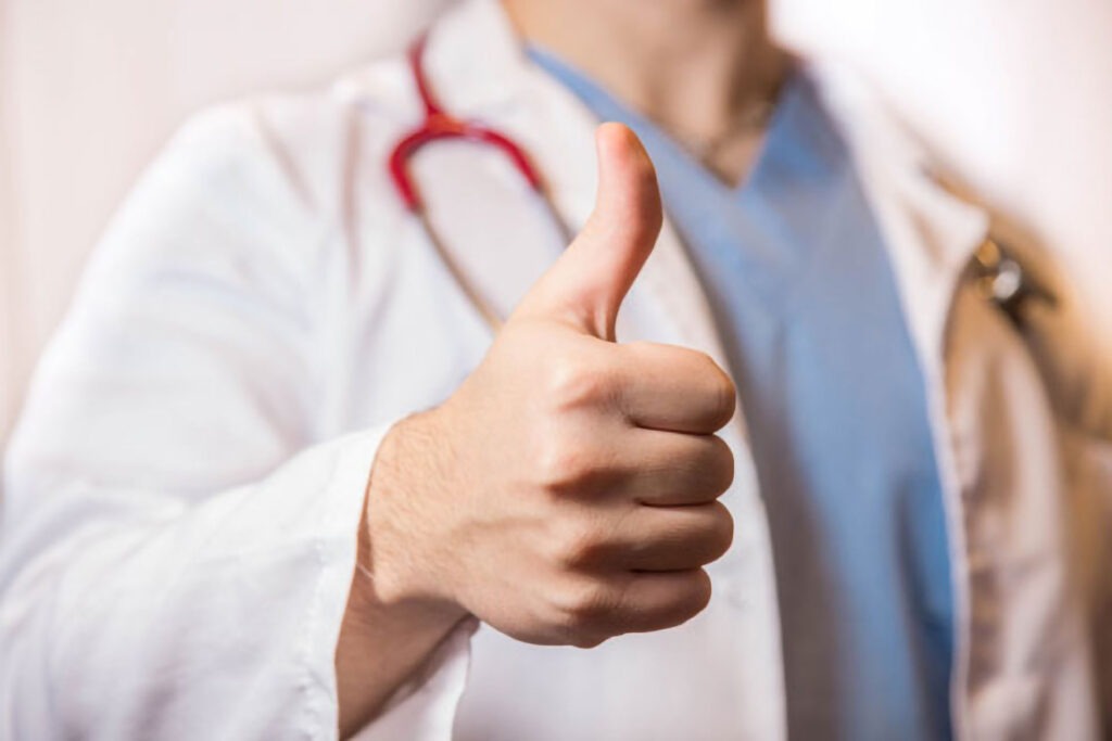 Primary Care background photo. Thumbs up by doctor.