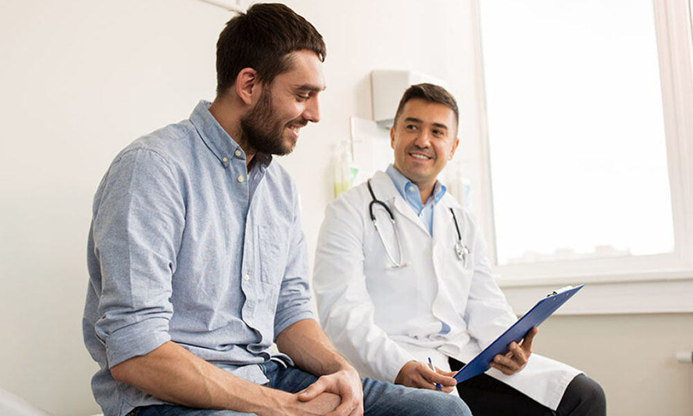 smiling doctor and young man meeting at hospital