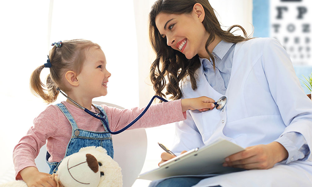 Little girl at the doctor for a checkup. Child auscultate the heartbeat of the doctor.