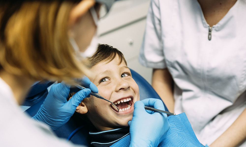 Dentists with a patient during a dental intervention to boy.