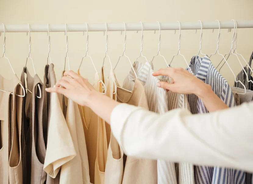 shirts on a rack, hands.